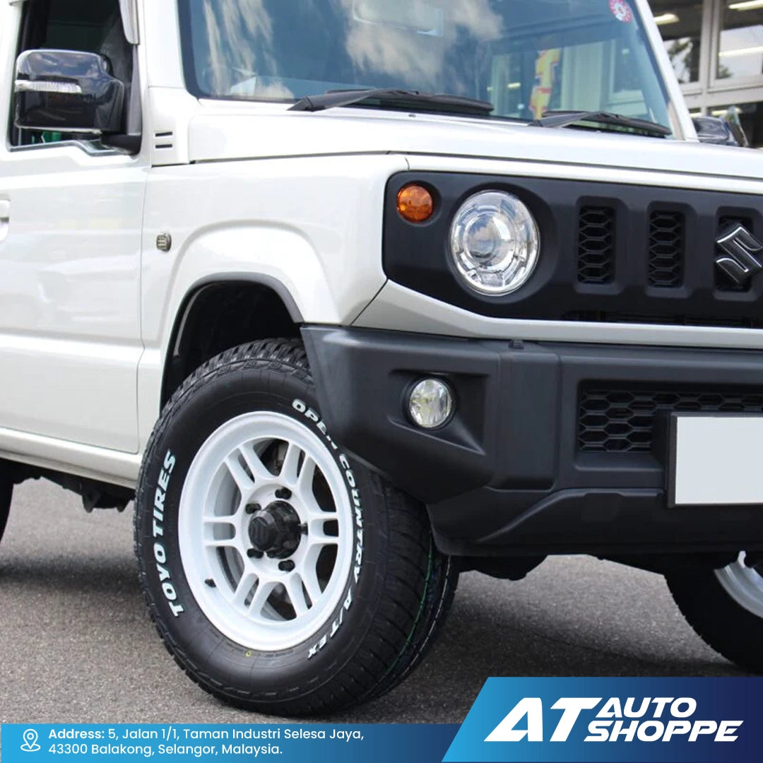 Close-up of a white SUV with a black front bumper and 'AT Auto Shoppe' branding.