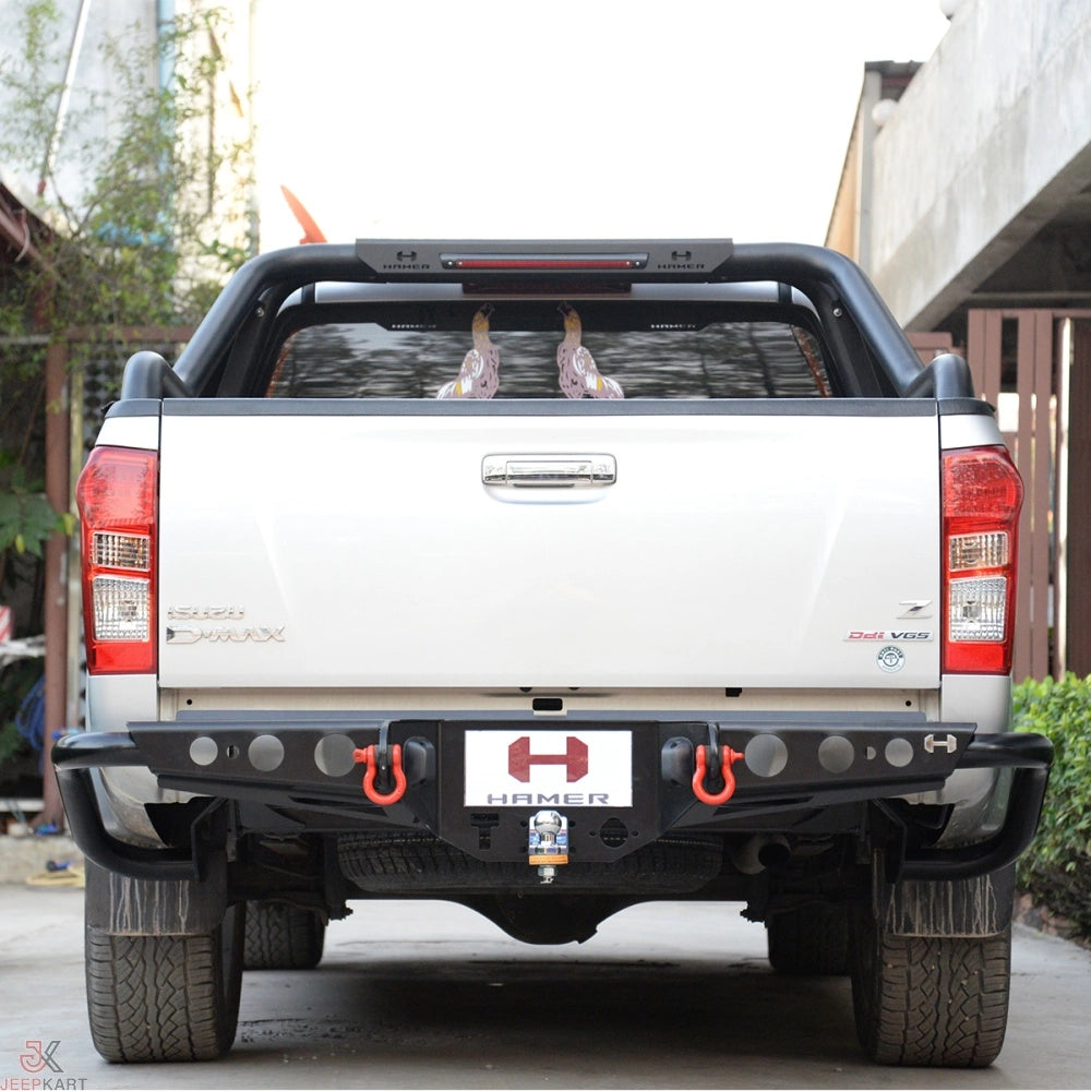 White pickup truck with a HAMER logo on the bumper, parked outdoors.