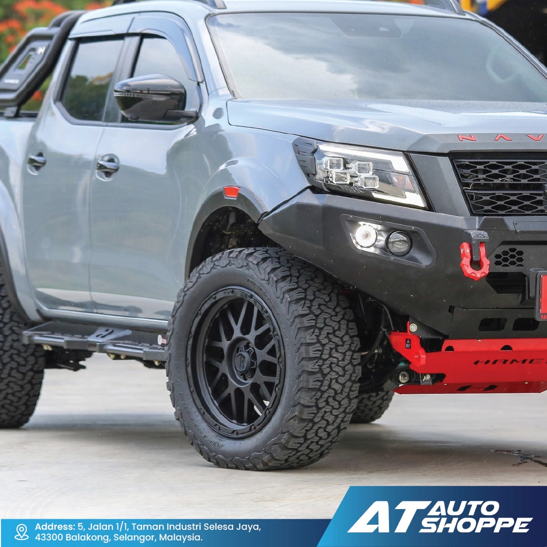 Gray pickup truck with black wheels and red bumper on a road, featuring AT Auto Shoppe branding.