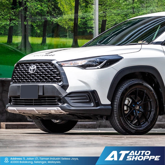 White Toyota SUV with black rims on a road with greenery in the background, featuring AT Auto Shoppe branding.