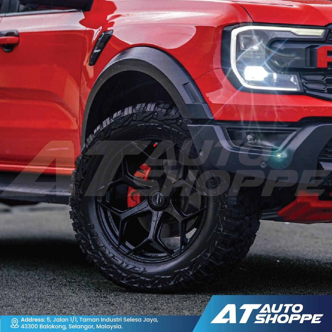 Close-up of a red vehicle with black tire and wheel, featuring AT Auto Shoppe branding.