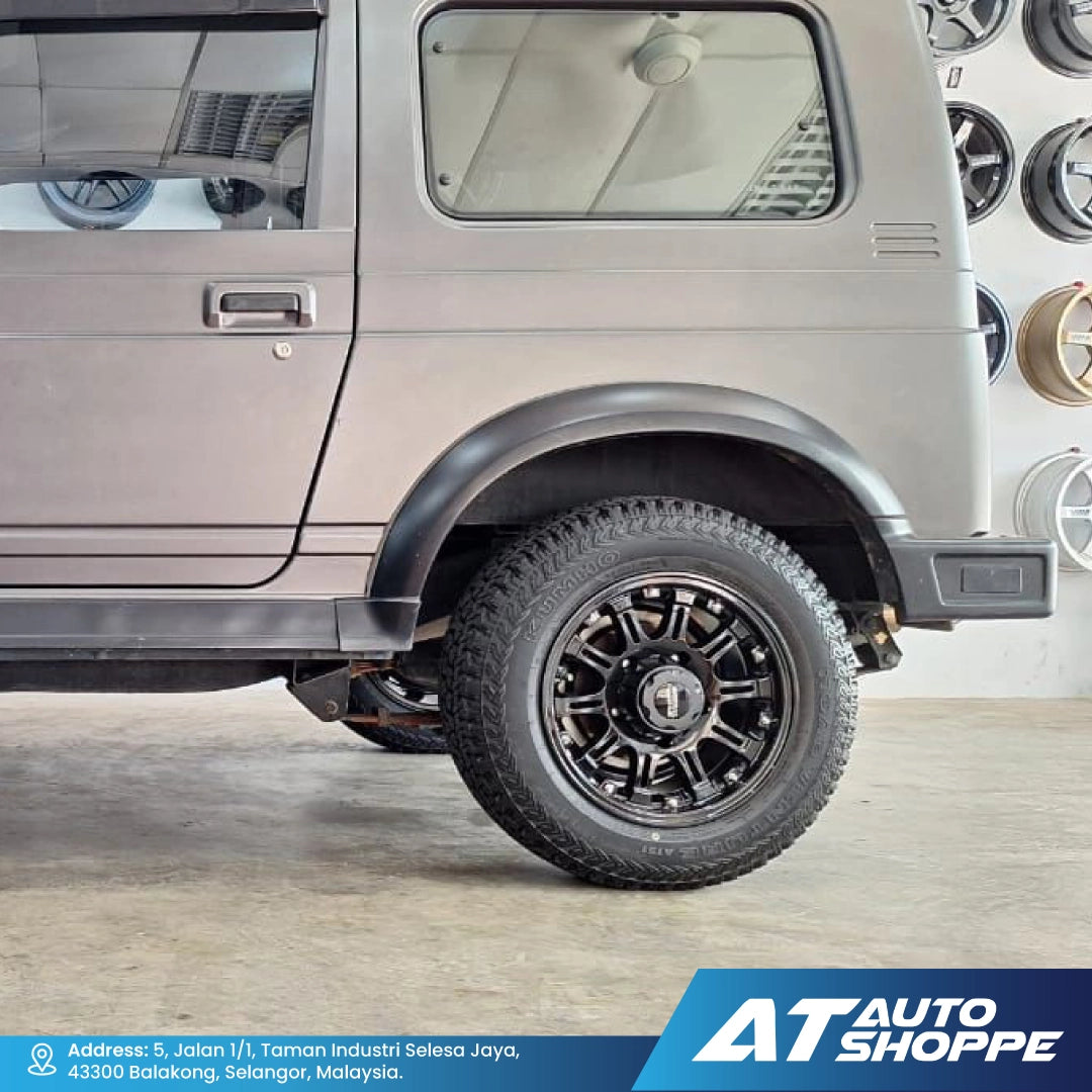 Side view of a vehicle with a black wheel and tire, featuring the AT Auto Shoppe logo.