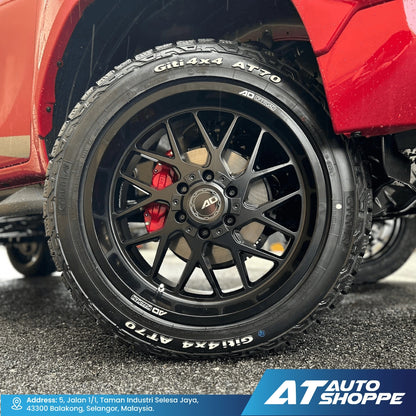 Close-up of a red vehicle's wheel with black rim and tire, featuring 'AD Wheels' branding. AT Auto Shoppe logo visible.