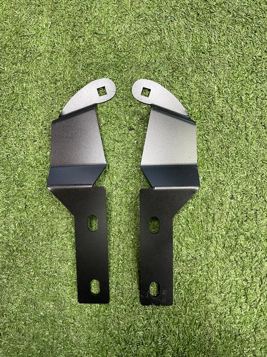 Two metal brackets on a green grass background
