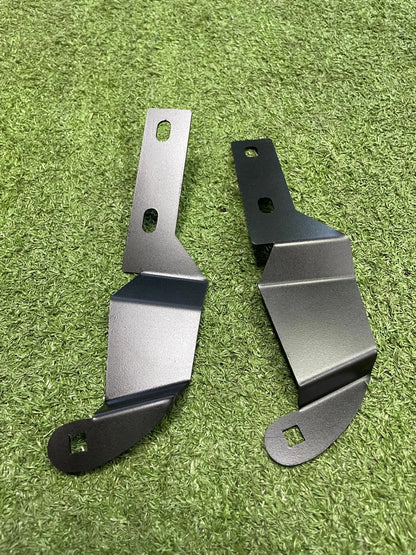 Two metal brackets on a green grass background