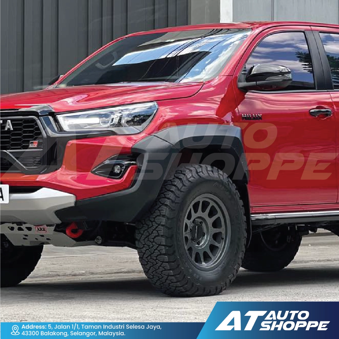 Red SUV with off-road tires and black fender flares on a gray background, featuring AT Auto Shoppe branding.