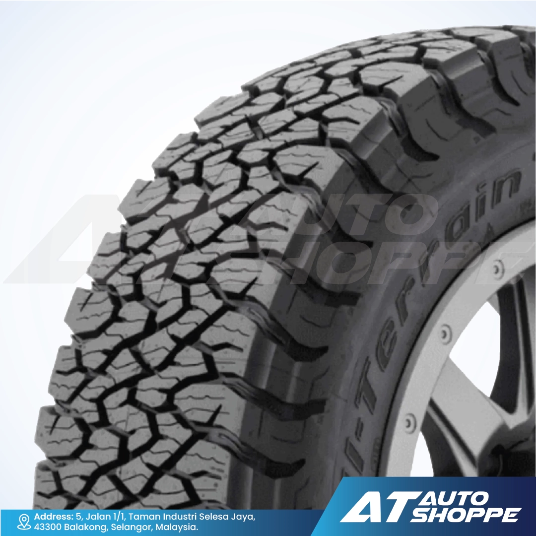 Close-up of a BFGoodrich tire with tread pattern on a white background, featuring the AT Auto Shoppe logo.