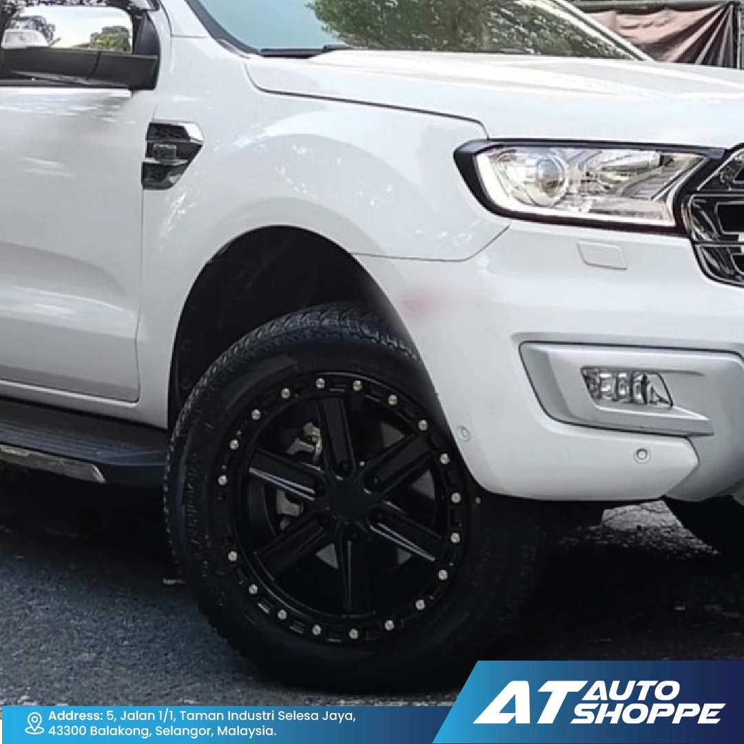 White SUV with black wheels on a road, featuring AT Auto Shoppe branding.