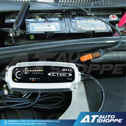Car battery charger with CTEK branding inside a vehicle, connected to a battery.