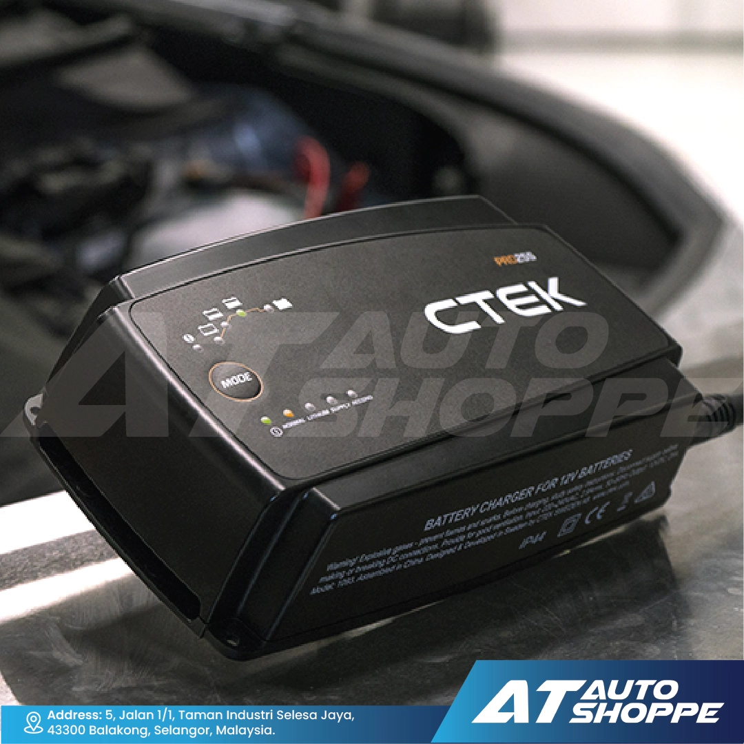 CTEK battery charger on a car battery with AT Auto Shoppe branding.