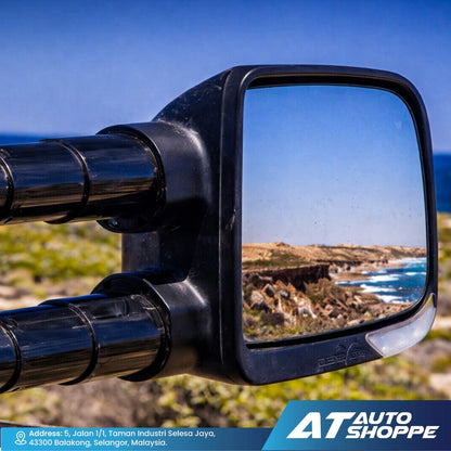 Side view mirror of a vehicle with a scenic reflection on a blue sky background, featuring AT Auto Shoppe branding.