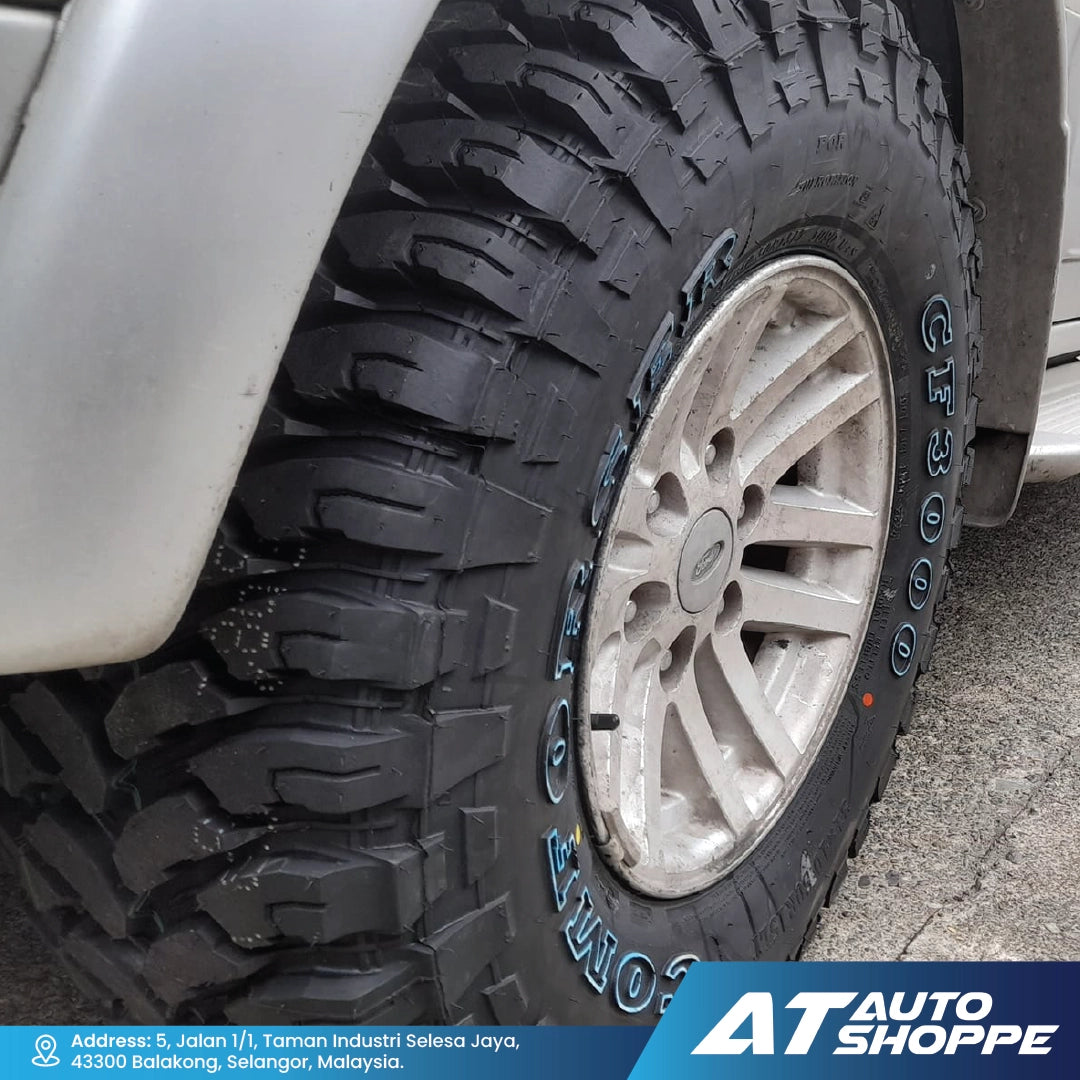 Close-up of a Comforser CF3000 tire with visible tread pattern and rim, branded with AT Auto Shoppe.