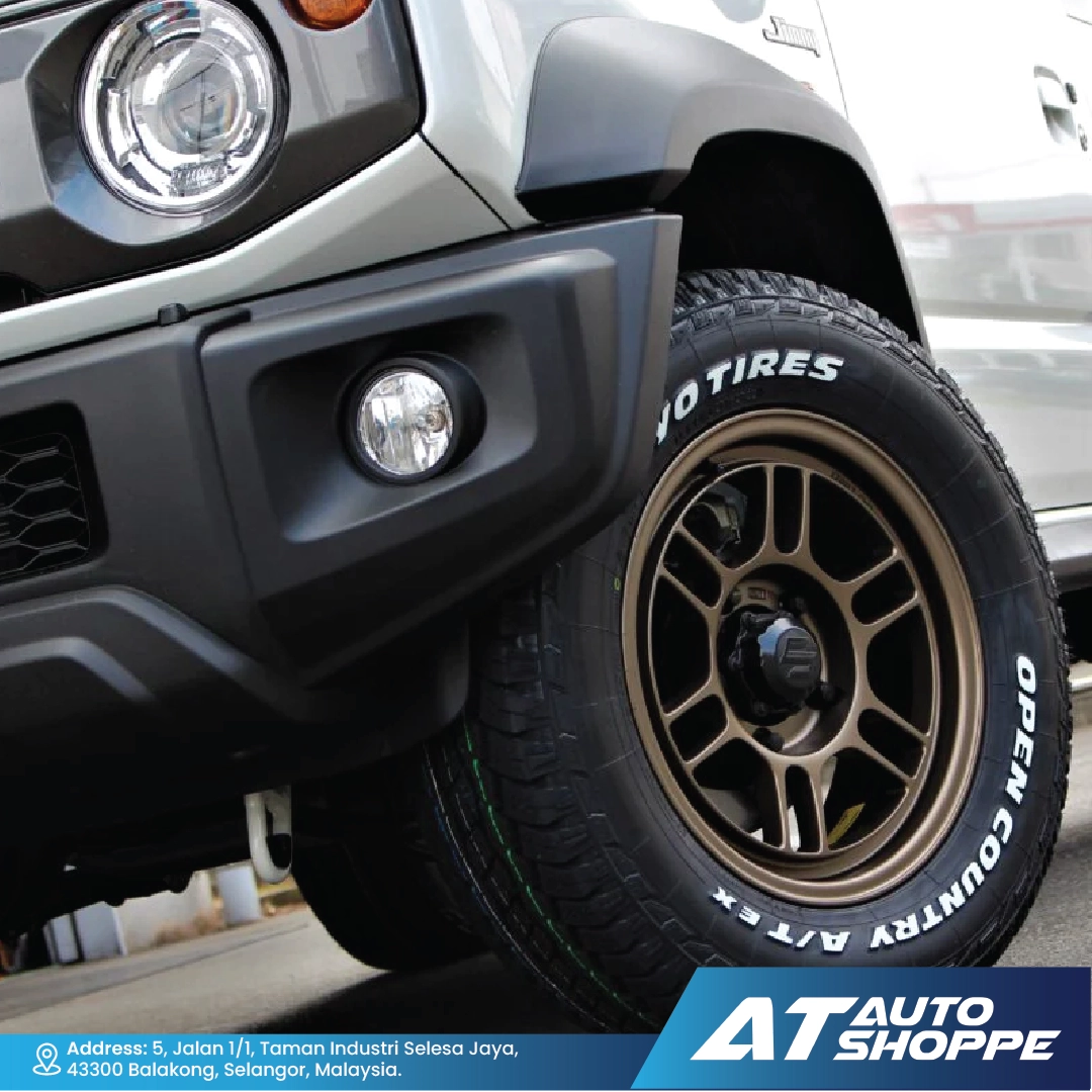 Close-up of a vehicle tire with 'Open Country' branding, featuring 'AT Auto Shoppe' logo.