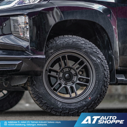Close-up of a black truck tire with AT Auto Shoppe branding.