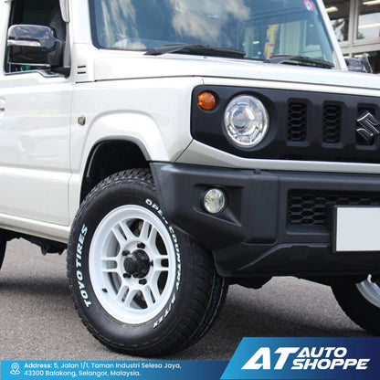 Close-up of a white SUV with a black front bumper and 'AT Auto Shoppe' branding.