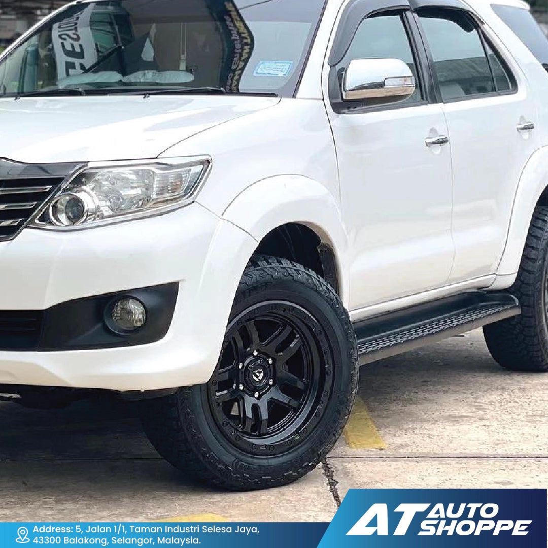 White SUV with black wheels on a concrete surface, featuring AT Auto Shoppe branding.