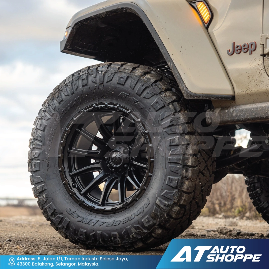 Close-up of a Jeep tire with off-road tread on a blurred natural background
