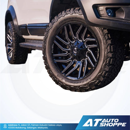 Close-up of a vehicle wheel with a visible tire and rim, featuring the AT Auto Shoppe logo.
