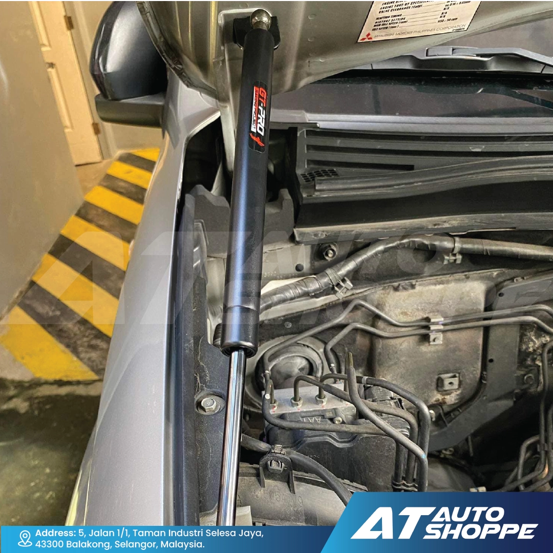 GT-Pro car suspension component with 'AT Auto Shoppe' branding in a garage setting.