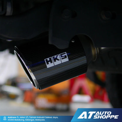 Car exhaust with HKS logo on a blurred background, featuring AT Auto Shoppe branding.