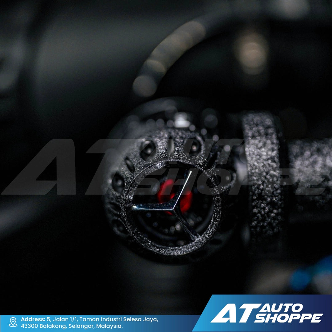 Steering wheel with logo and 'AT Auto Shoppe' branding in the background