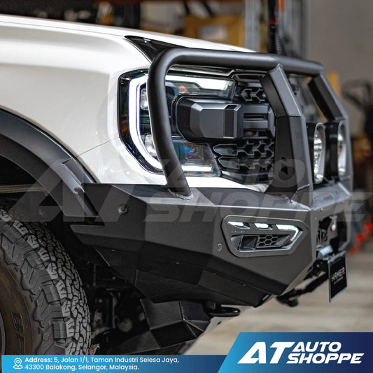 Close-up of a vehicle's front bumper with 'AT Auto Shoppe' branding.