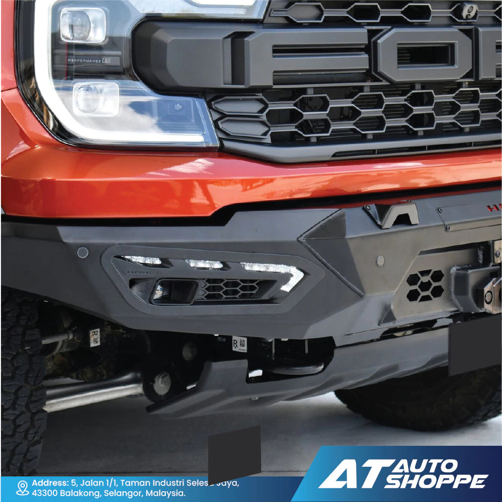 Close-up of a red truck's front grille and bumper with 'AT Auto Shoppe' branding.