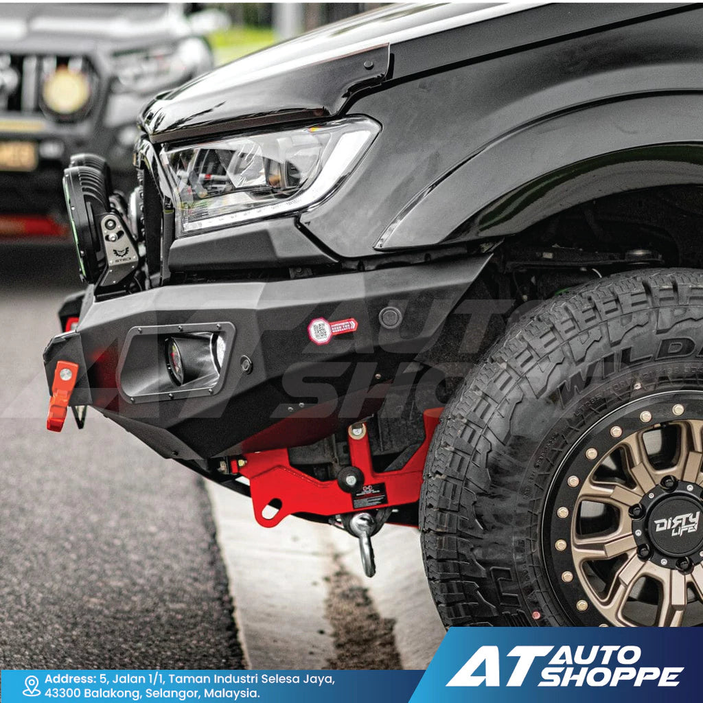 Close-up of a black off-road vehicle with red bumper on a road, featuring AT Auto Shoppe branding.