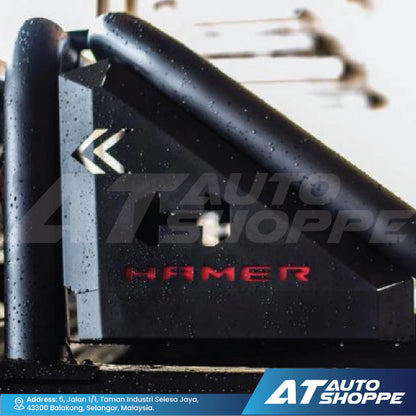 Black metal bracket with 'Hamer' branding on a blurred background with 'AT Auto Shoppe' branding.