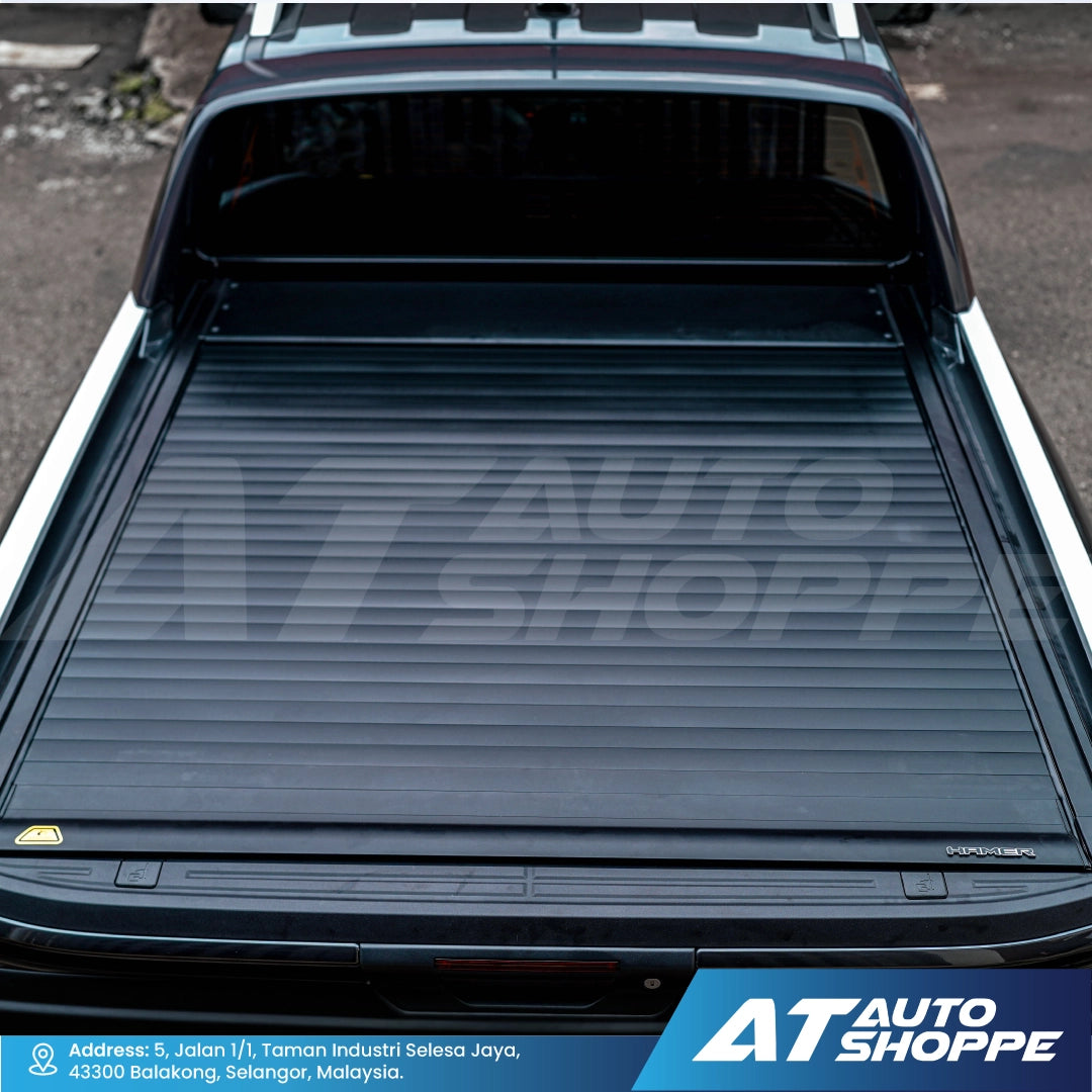 Truck bed with a tonneau cover, featuring AT Auto Shoppe branding.