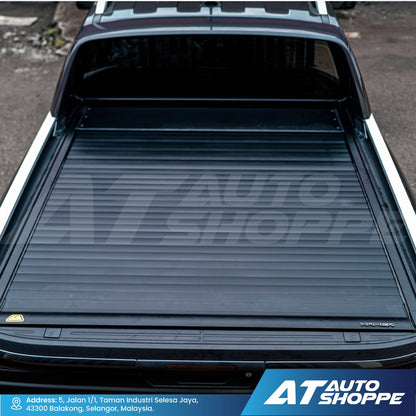 Truck bed with a tonneau cover, featuring AT Auto Shoppe branding.
