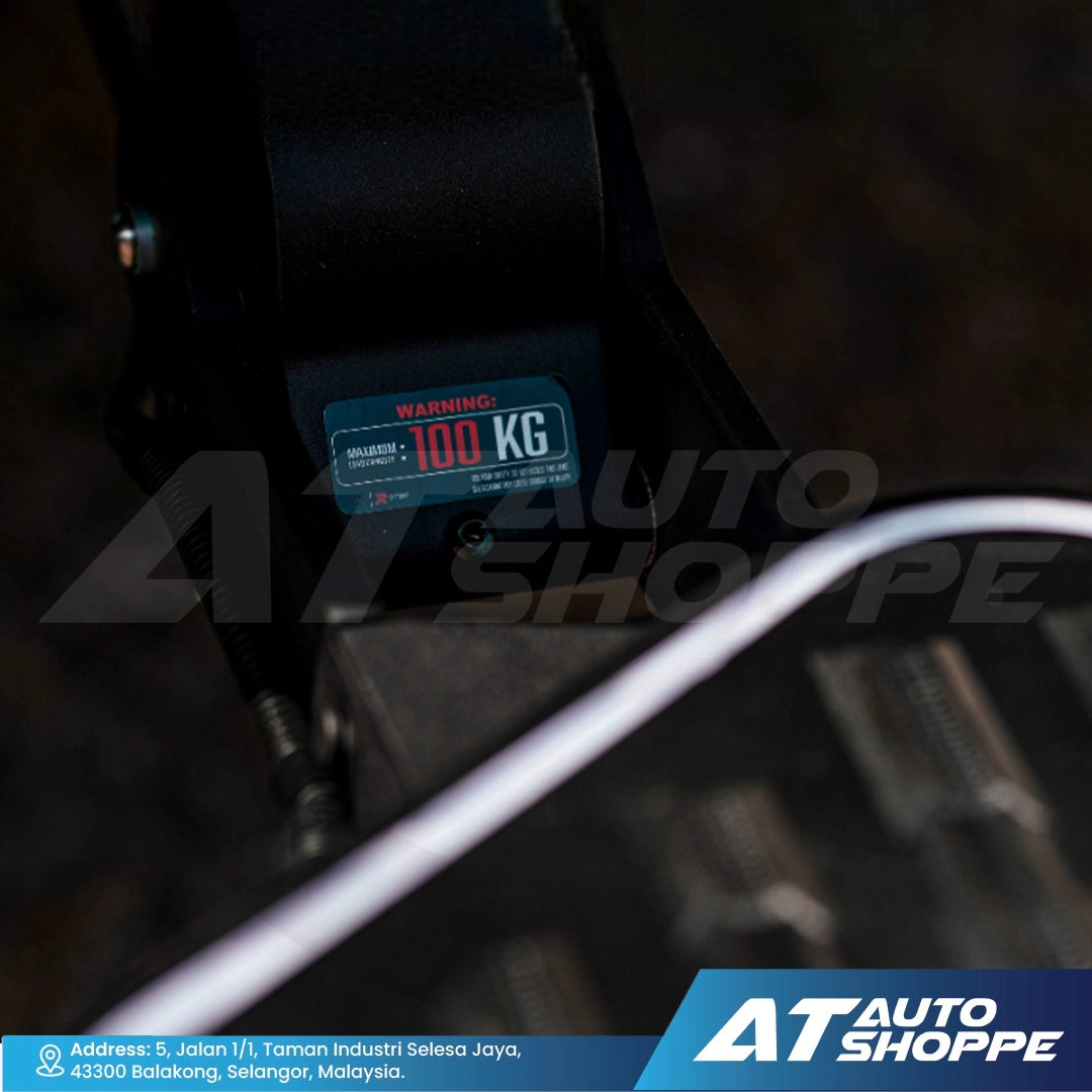 Close-up of a seat belt with a weight indicator label, blurred background, AT Auto Shoppe branding.