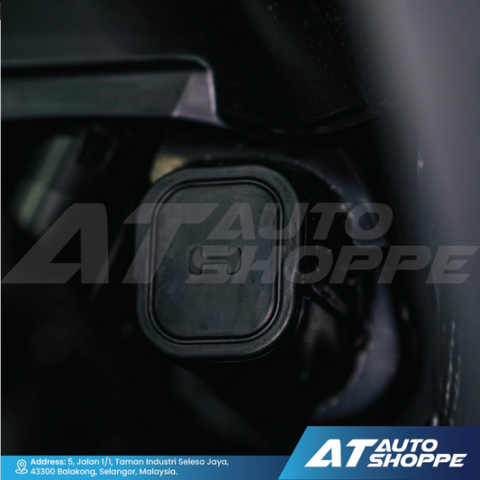 Close-up of a car's gear shift lever with 'AT Auto Shoppe' branding.