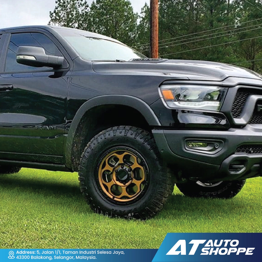 Black pickup truck with gold rims on grass, AT Auto Shoppe branding visible