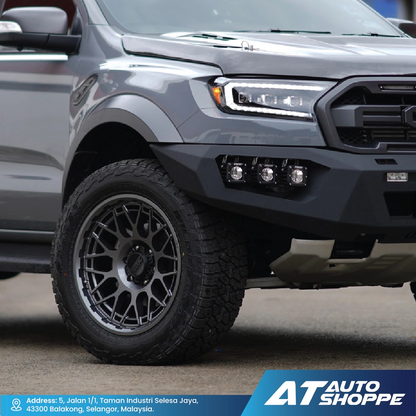 Gray pickup truck with black wheels on a road, featuring AT Auto Shoppe branding.