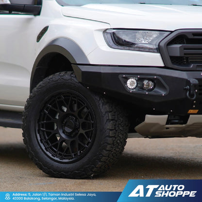 Close-up of a white truck with black wheels and bumper, featuring AT Auto Shoppe branding.