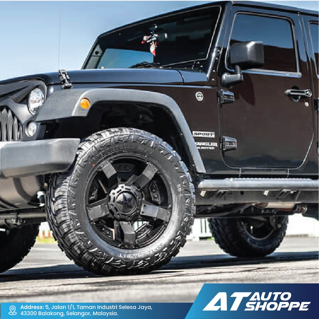 Black Jeep Wrangler withXD Wheels rims on a road, featuring AT Auto Shoppe branding.