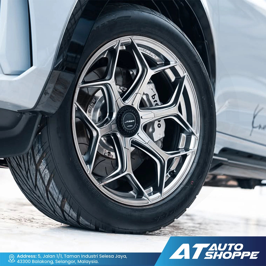 Close-up of a car wheel with a detailed rim design, featuring the AT Auto Shoppe logo.