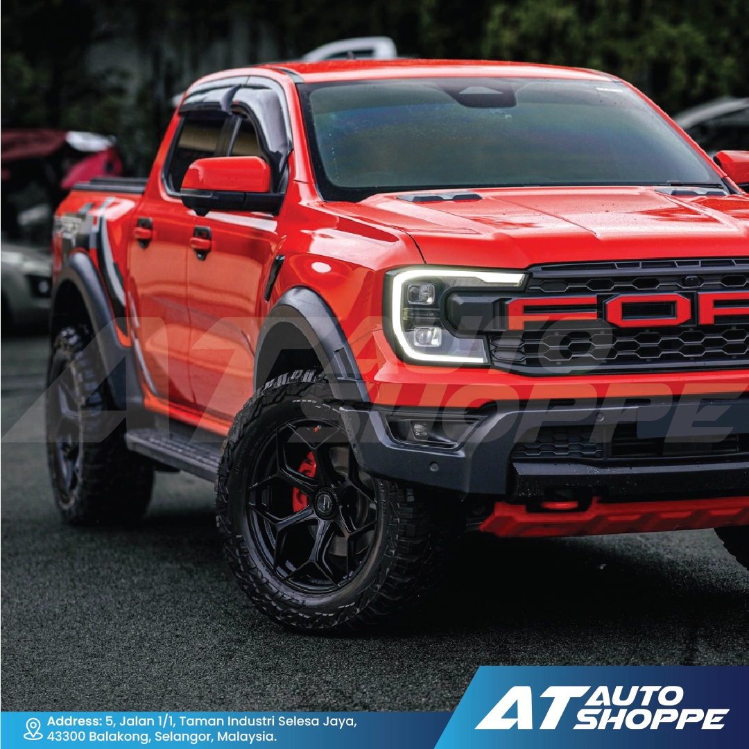 Red Ford truck with black accents on a road, featuring the AT Auto Shoppe logo.