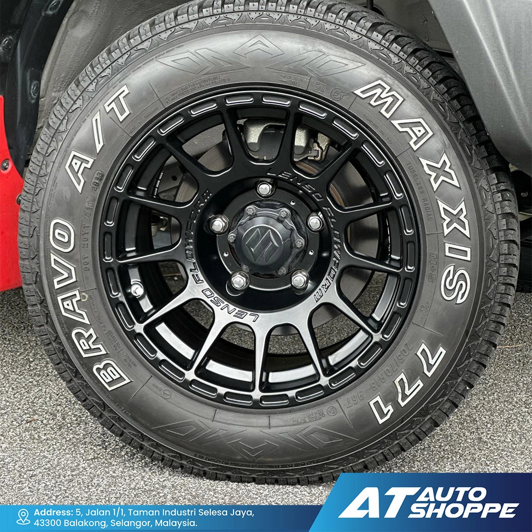 Close-up of a Maxis Bravo A/T tire on a vehicle, with 'AT Auto Shoppe' branding.