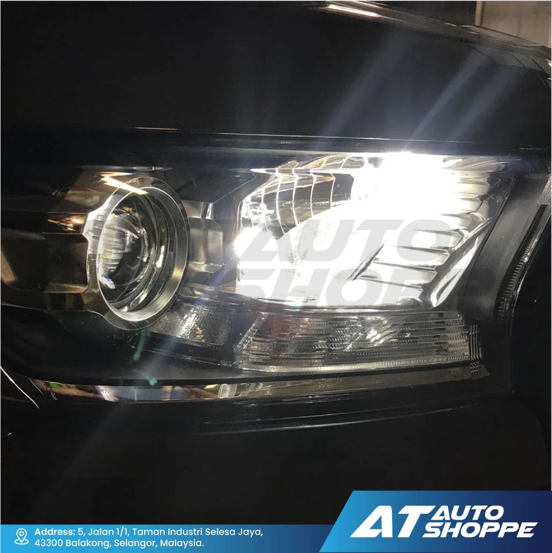 Car headlight with 'AT Auto Shoppe' branding in the corner