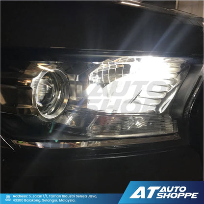 Car headlight with 'AT Auto Shoppe' branding in the corner