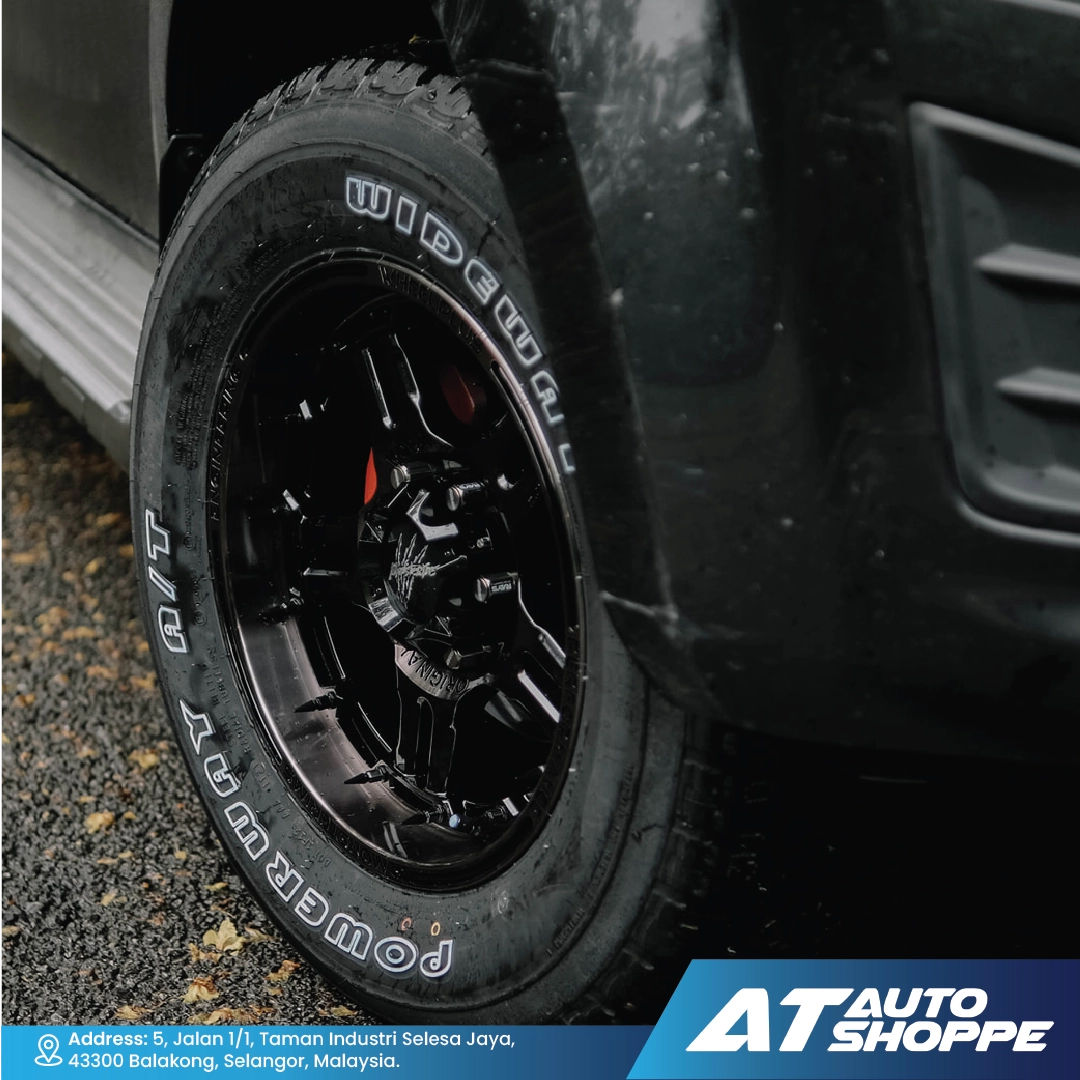 Close-up of a tire with visible branding on a vehicle, featuring the brand 'AT Auto Shoppe'.