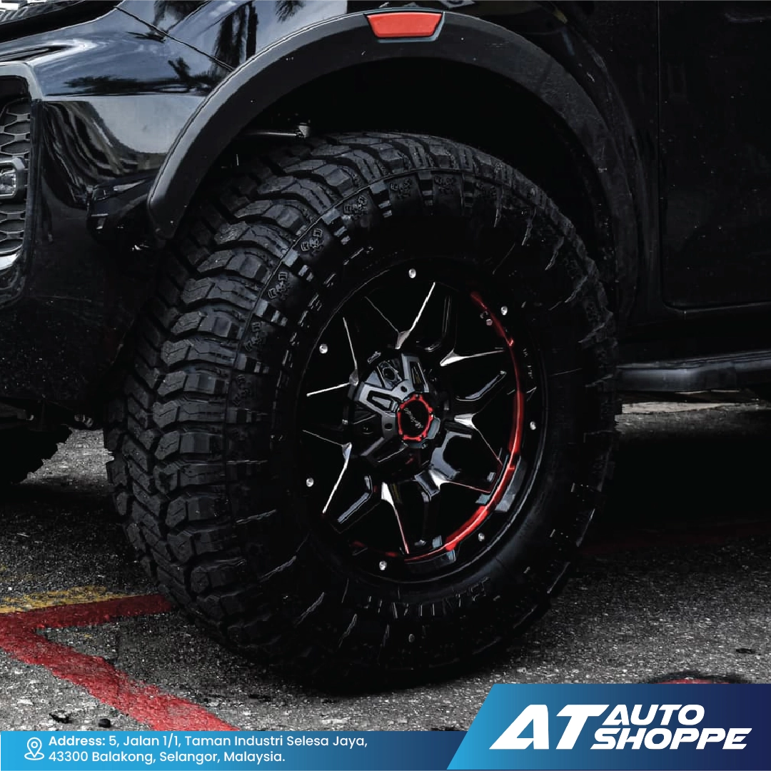 Close-up of a black tire with Monsterims wheels, featuring the AT Auto Shoppe logo.