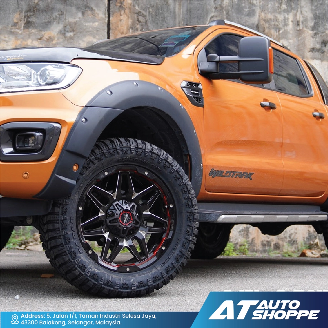 Orange pickup truck with Monsterims wheels and 'AT Auto Shoppe' branding.
