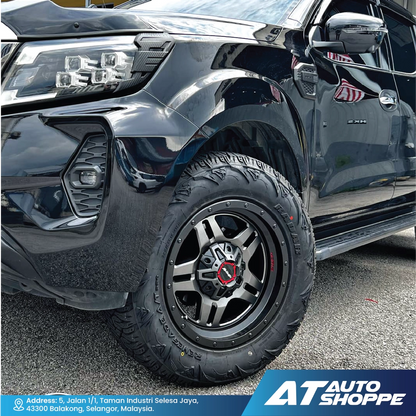 Close-up of a black truck featuring a Monsterims wheel, with the AT Auto Shoppe logo.
