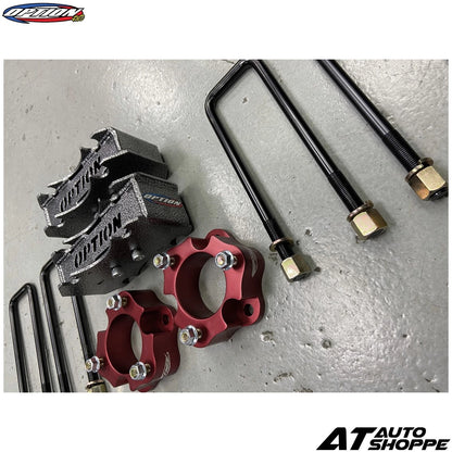 Automotive suspension components on a gray surface with 'AT Auto Shoppe' branding.