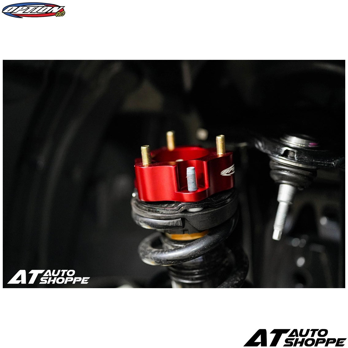 Close-up of a red mechanical component on a black background with 'AT Auto Shoppe' branding.