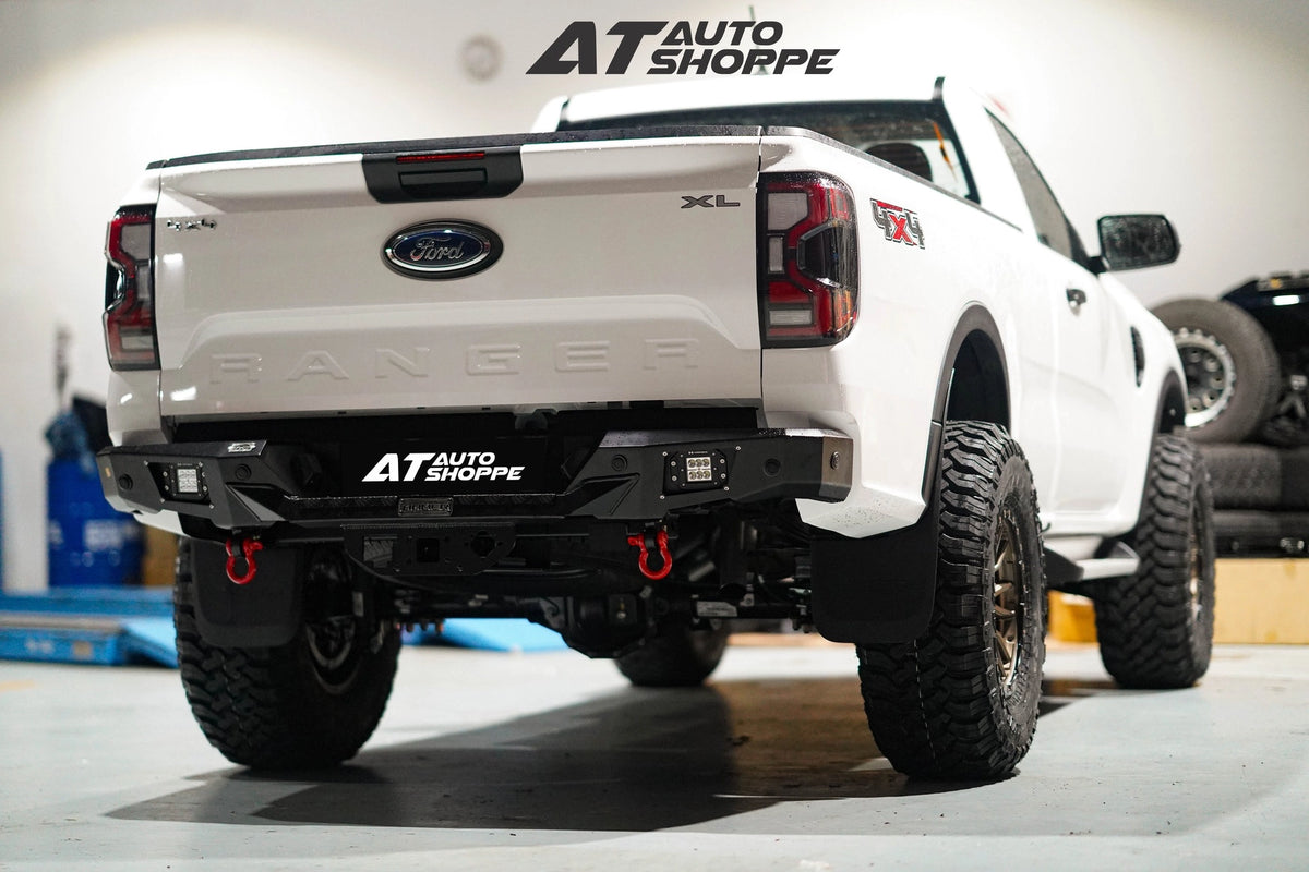 White pickup truck with 'AT Auto Shoppe' branding in a garage setting