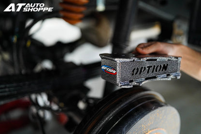 Car part with 'OPTION' branding on a blurred background of an auto shop.